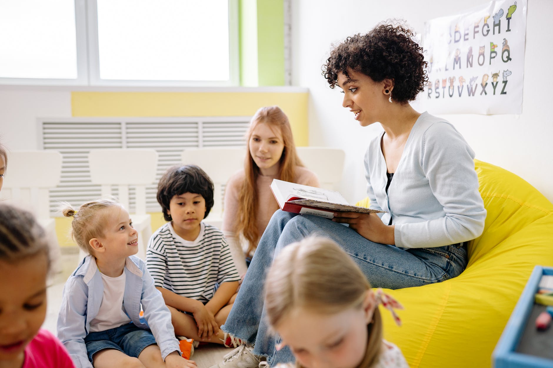 woman reading a book to the children in Fill in the Blank Questions for Kids